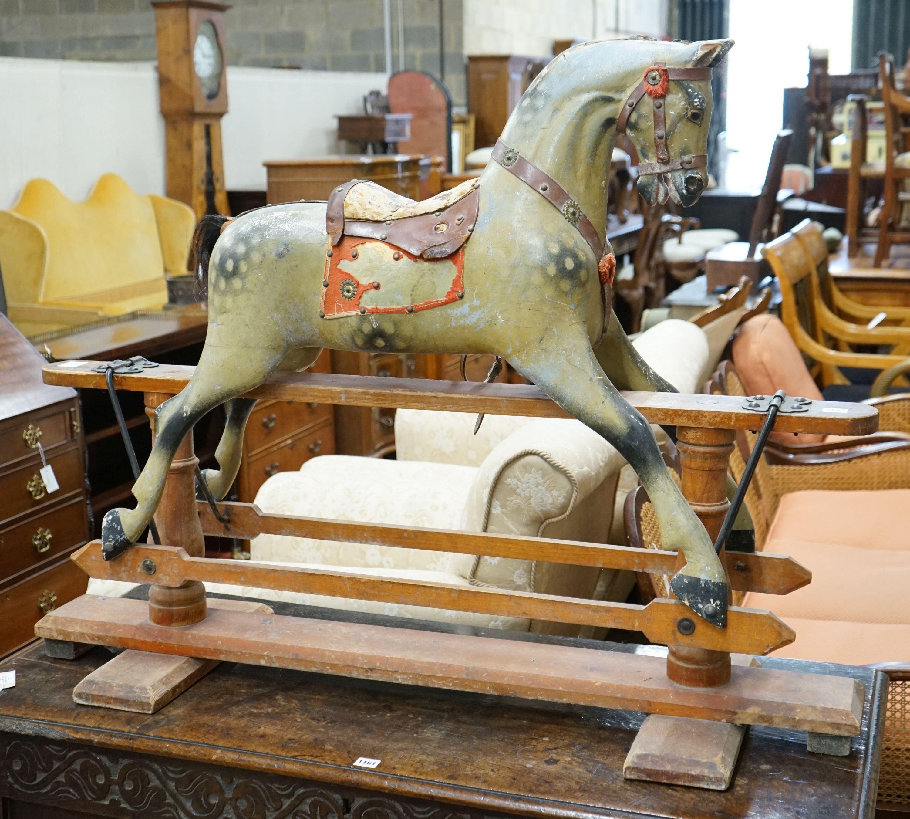 An Edwardian carved wood and dapple painted rocking horse, raised in a trestle frame, length 127cm, height 95cm